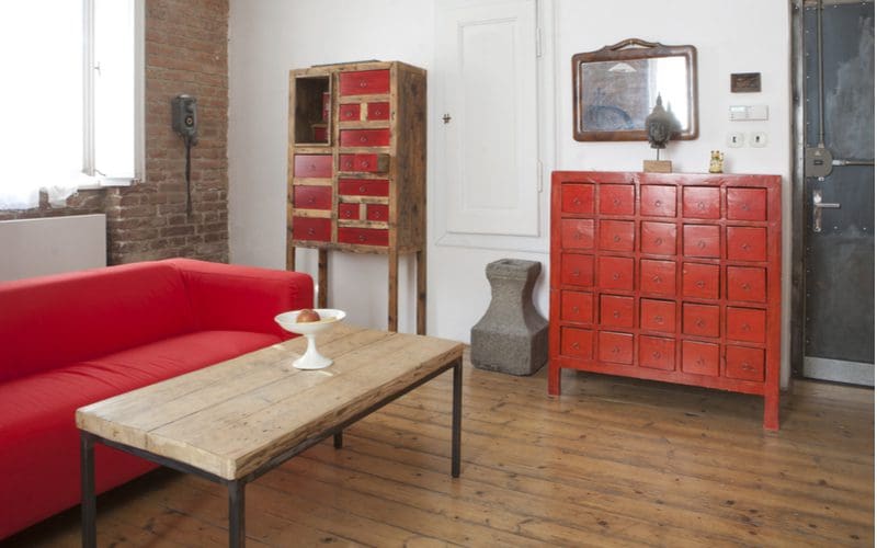 Home in the industrial style making good use of red furniture, white walls, and brown hardwood floors