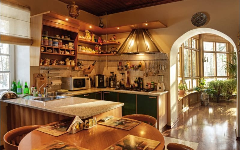 Rustic style cabinets made of hardwood and painted green in a French-style kitchen with ample brown and rustic coloring