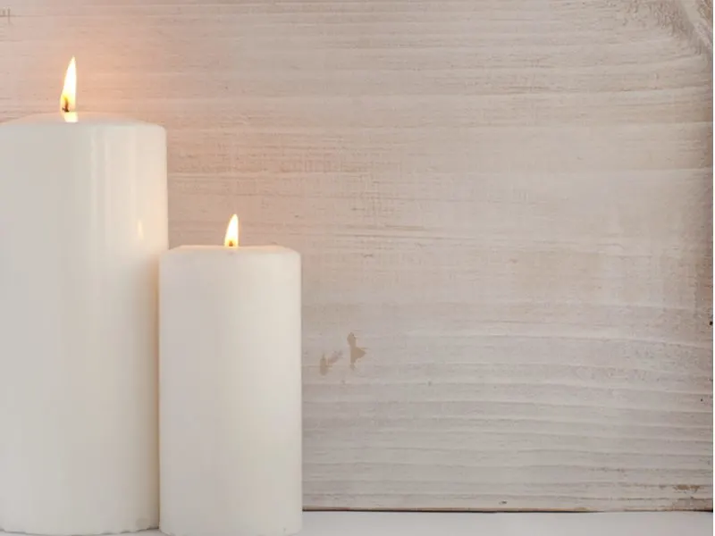 Pillar candles against a barnwood wall covering