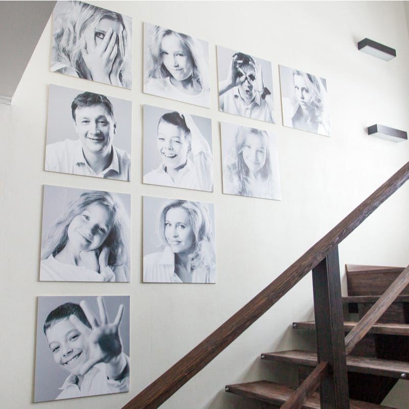 Decorating idea for stairs featuring black and white family portraits attached to the wall