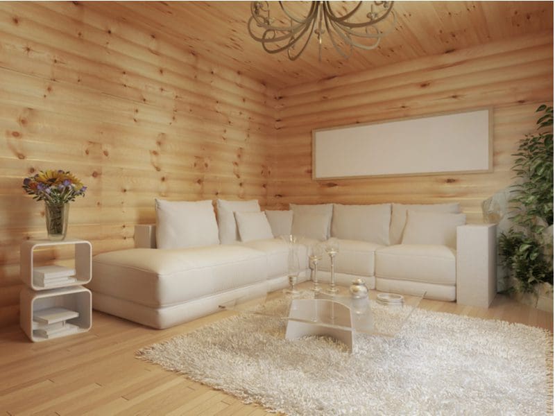 Interior cabin idea with beige furniture in the middle of a wood-paneled room