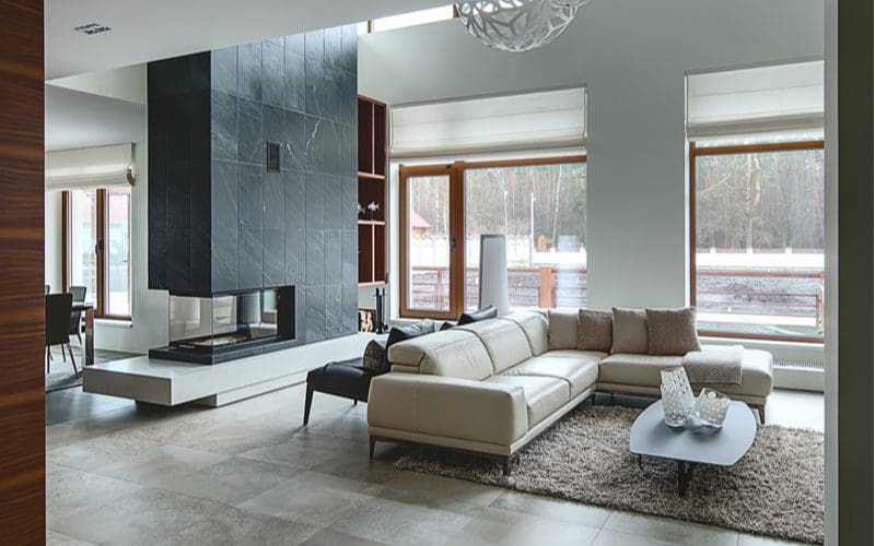 Sleek, modern, and expensive cottage interior with slate tile on the fireplace and ceramic tile in tan color on the floor
