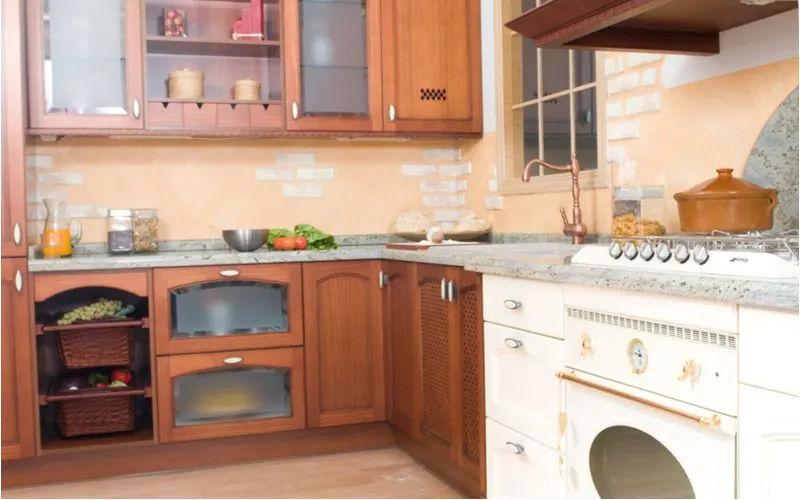 Narrow style rustic farm cabinets in dark brown color with white appliances and tan and white backsplash