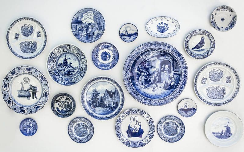 Kitchen wall decor in the form of blue and white plates attached to a simple white wall