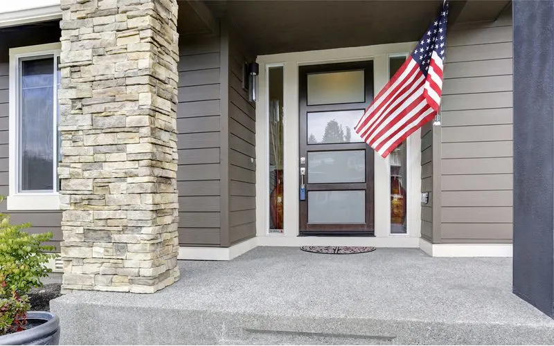 American flag hanging from the right side of a home entryway under a covered patio