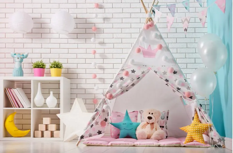 Cozy Play Tent in a room with brick walls and lots of fun room decor for a piece on cute rooms for girls