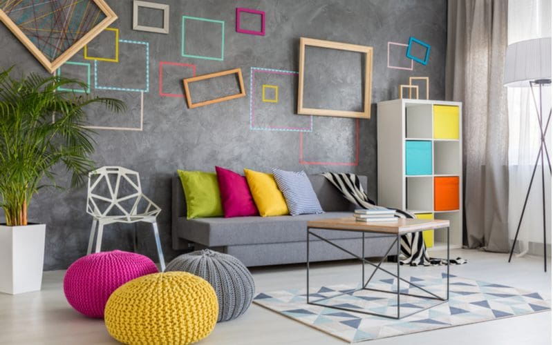 For a piece on interior design styles, a contemporary living room with a grey wall decorated by modern square frames painted in various colors