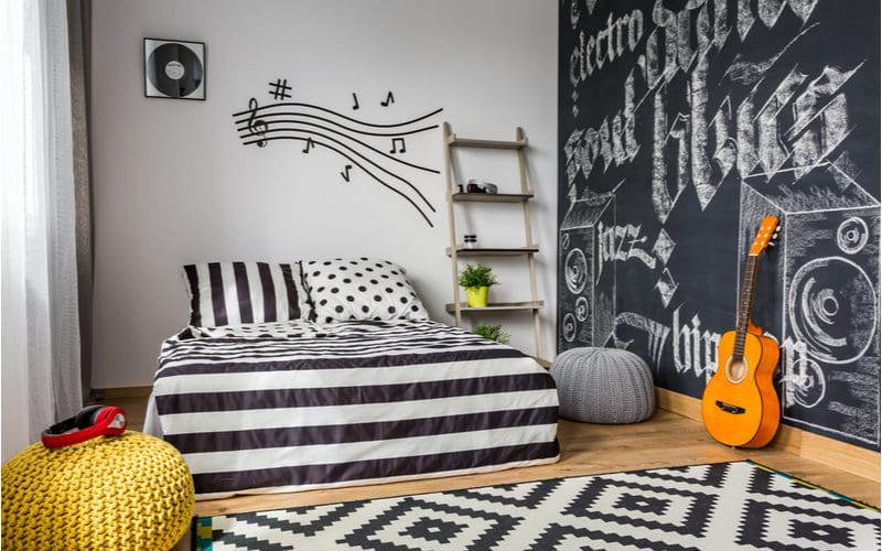 Teen boys room decorating idea featuring Monochrome Hues and a chalkboard wall next to the white and black striped bed