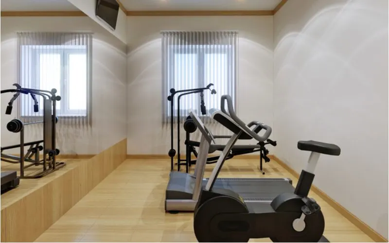 Small home gym with wooden floors and white walls with recessed lighting in the ceiling