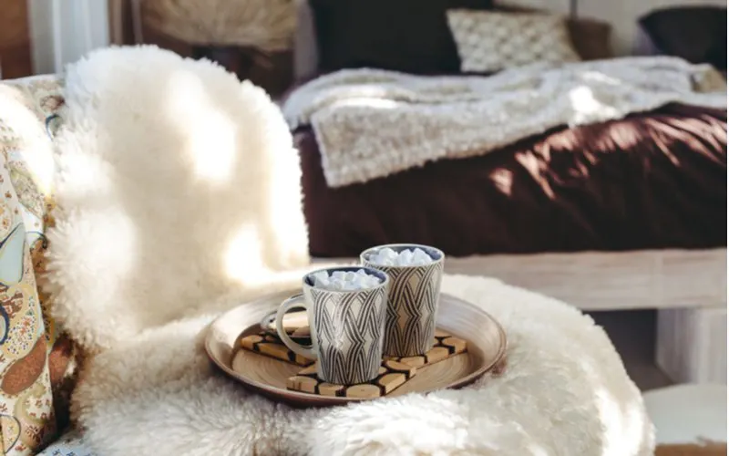 Sheepskin blanket on a table holding up hot cocoa and a drink tray