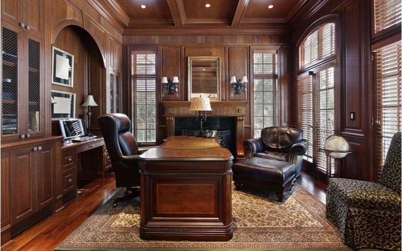 Executive home office idea featuring lots of rich mahogany on the walls, shelves, and ceiling