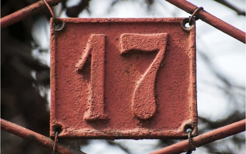 House numbers attached to a gate in a stamped metal style