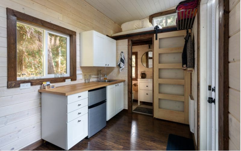 Interior cabin design with a farmhouse style sliding door and ample natural wood paneling on the walls and ceiling