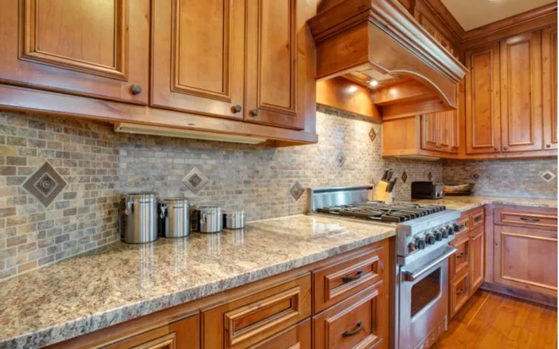Kitchen with brown cabinets with brown subway tile backsplash in stone color