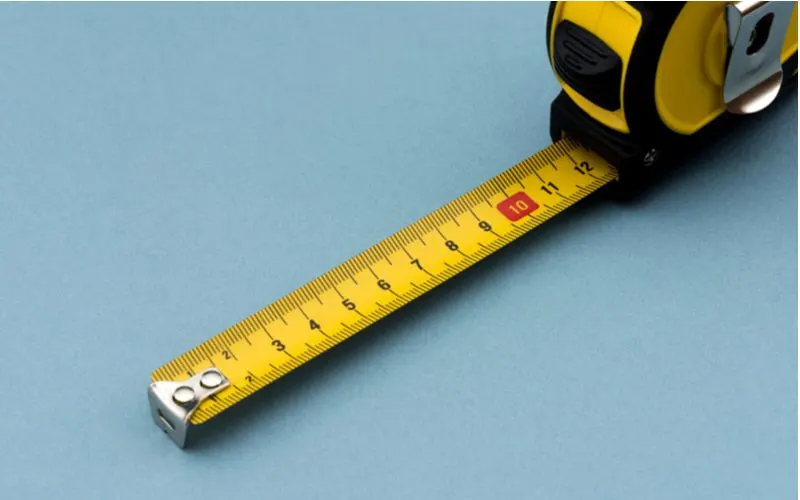 Tape measure laid out on a blue surface for a piece on types of measuring tools