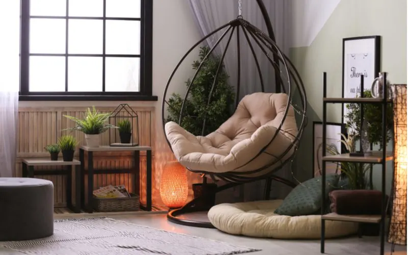 Image of a room idea featuring a papasan chair with metal frames and tan cushions with wooden accents and a black window frame