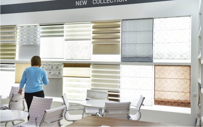 For a piece on living room blinds or curtains, a woman standing in a hardware store looking at window covering options