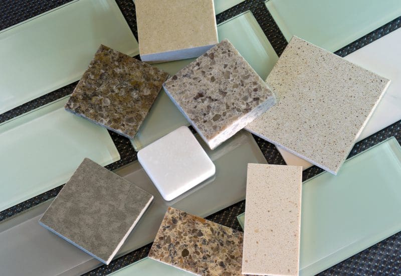 Subway tile in various colors and styles sits in a layflat image below a bunch of granite samples