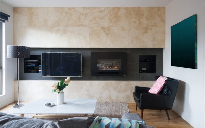 Living room with Corner Wrapped Fireplace and TV against a gray wall