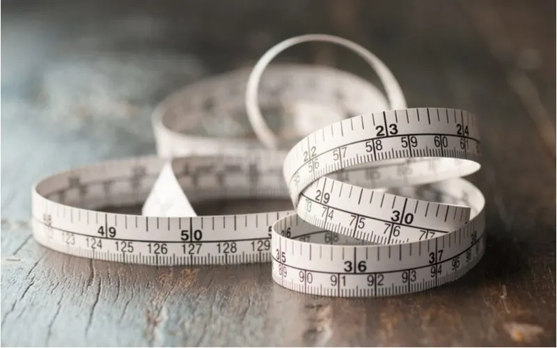 Measuring tape (a great type of measuring tool) rolled up on a wooden table