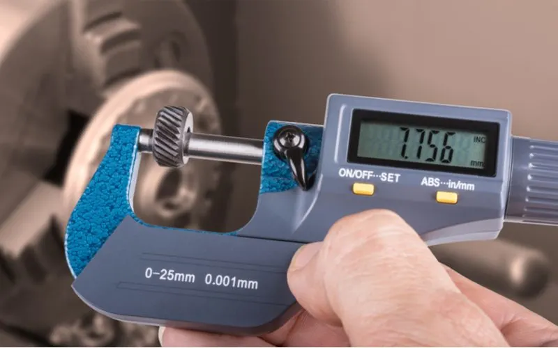 As a tool for types of measuring, a hand using a micrometer that's blue in color and small in size