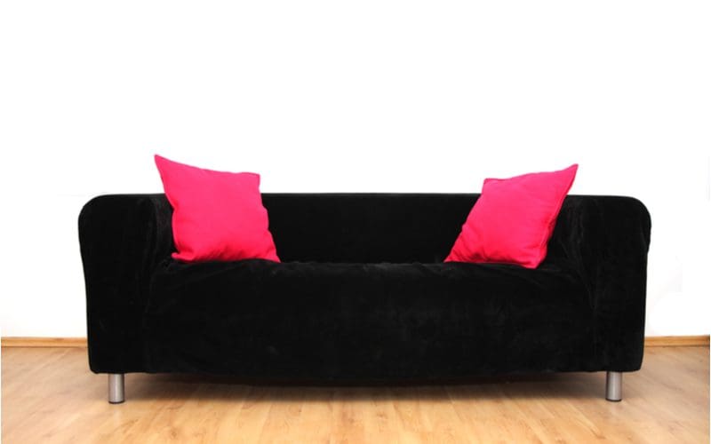 Making a black sofa look feminine with pink pillows