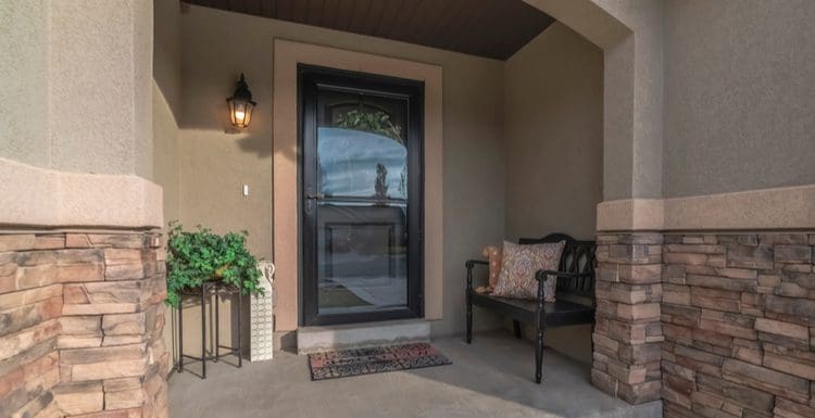 Home with a glass front door next to rock siding