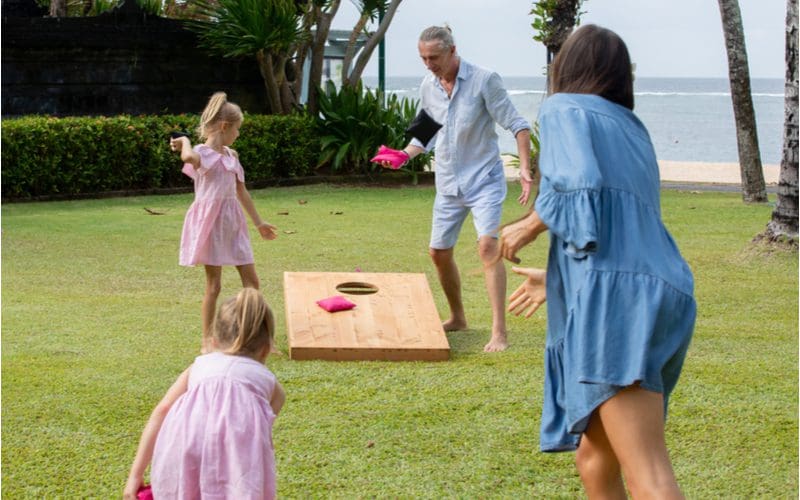 Standard cornhole board dimensions with a woman tossing a bean bag