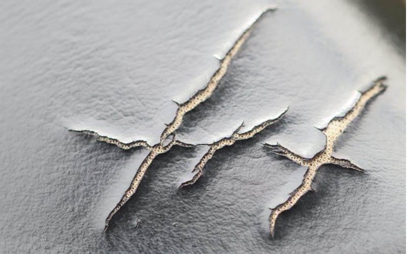 Cracks in black leather to illustrate how to stop leather from peeling