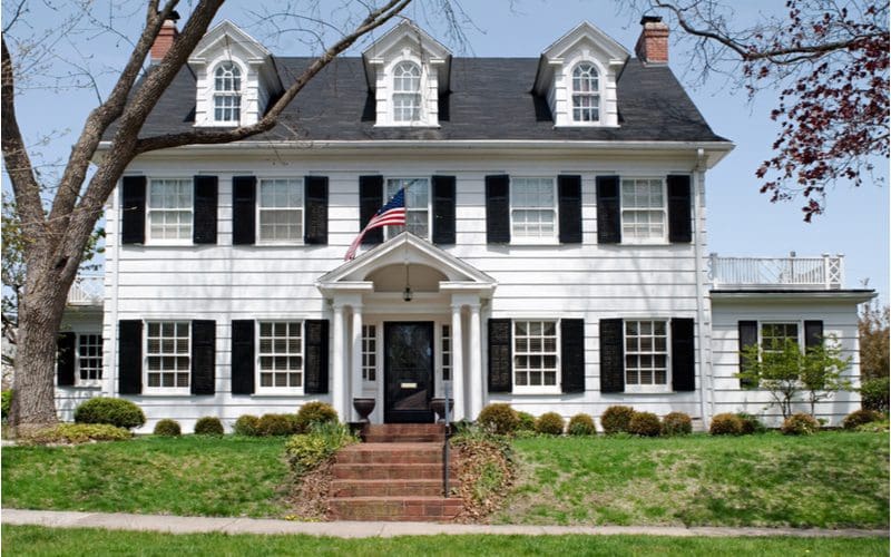 White Colonial House With Black and Red Roof