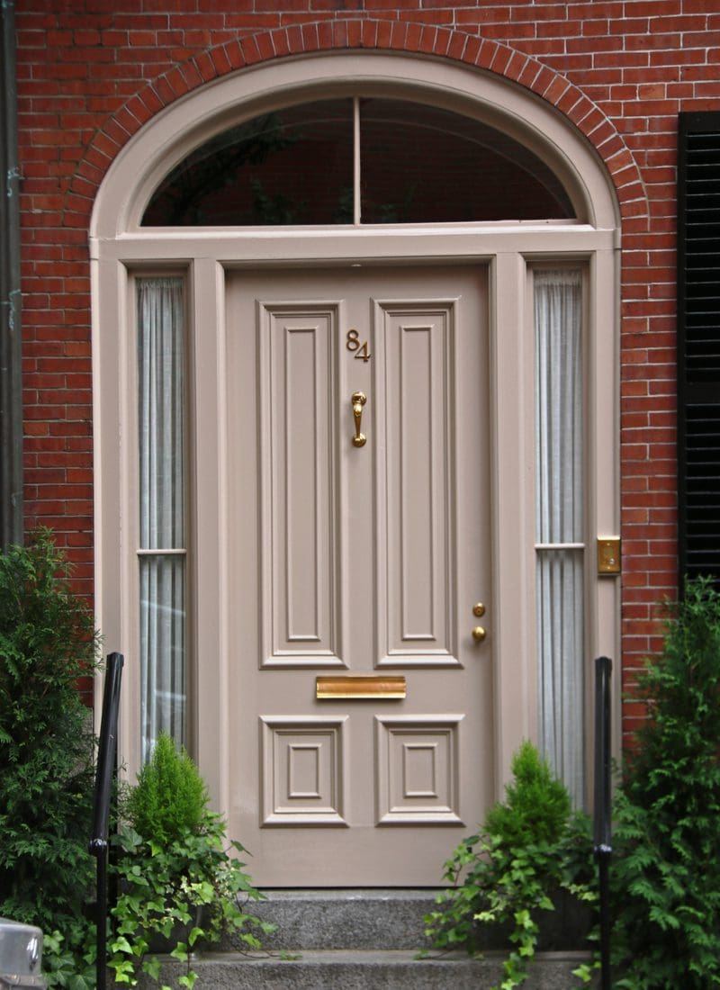 Cream color front door on a brown house