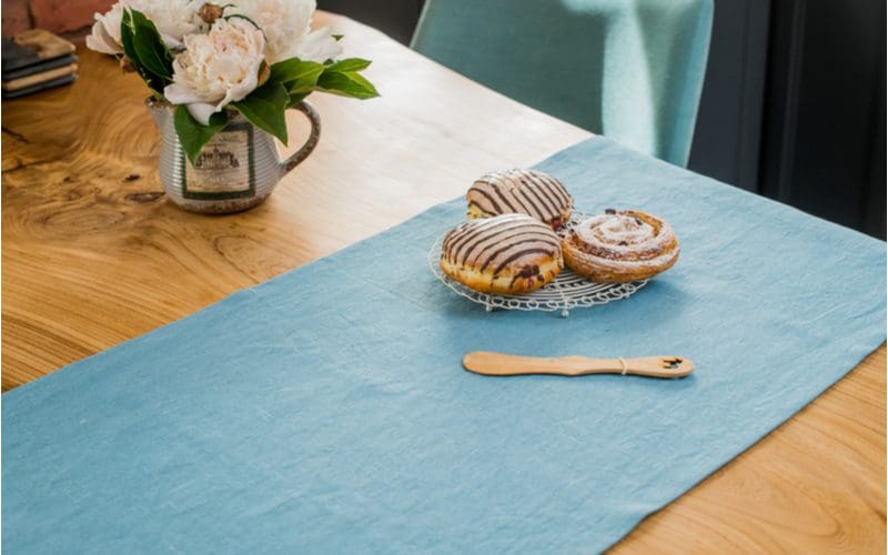 Idea for a blue and brown kitchen to Lay Linen Tablecloths on a Light Wooden Table