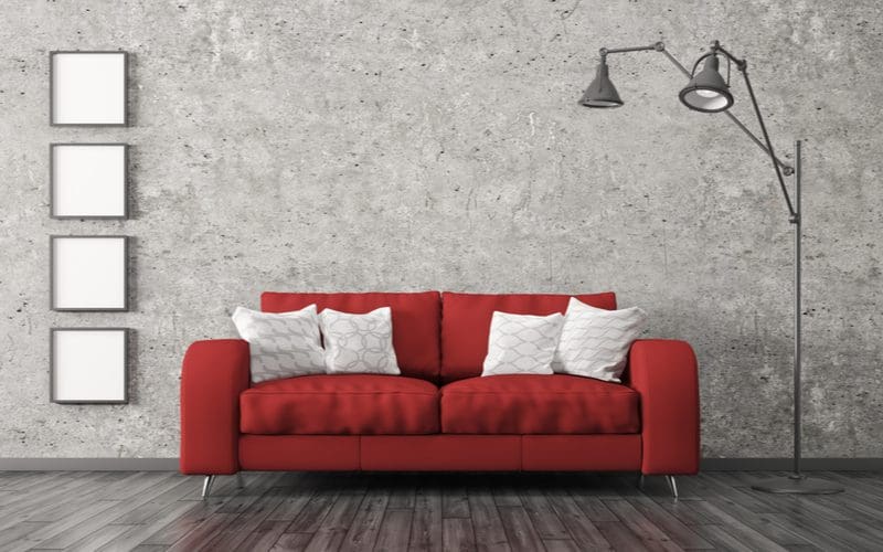 Neon red couch in a grey living room to illustrate what color furniture goes well with gray walls