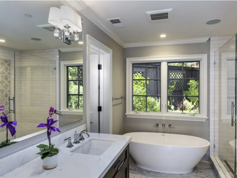 Master bathroom layout idea with a towel rack and tub in front of the window