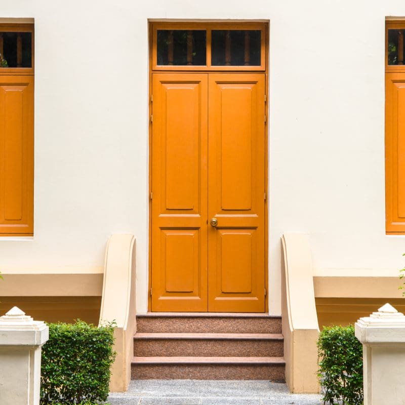 Orange, a, bold front door color for a white house