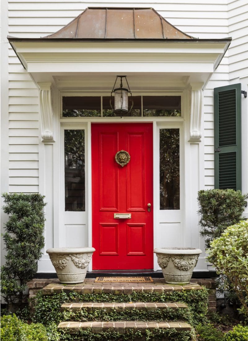 Red, one of the best front door colors for white houses, on a father of the bride looking house