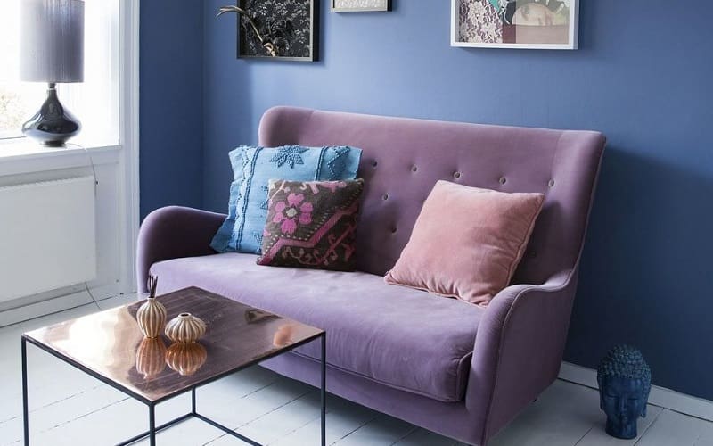 Navy blue walls combined with lavender couch
