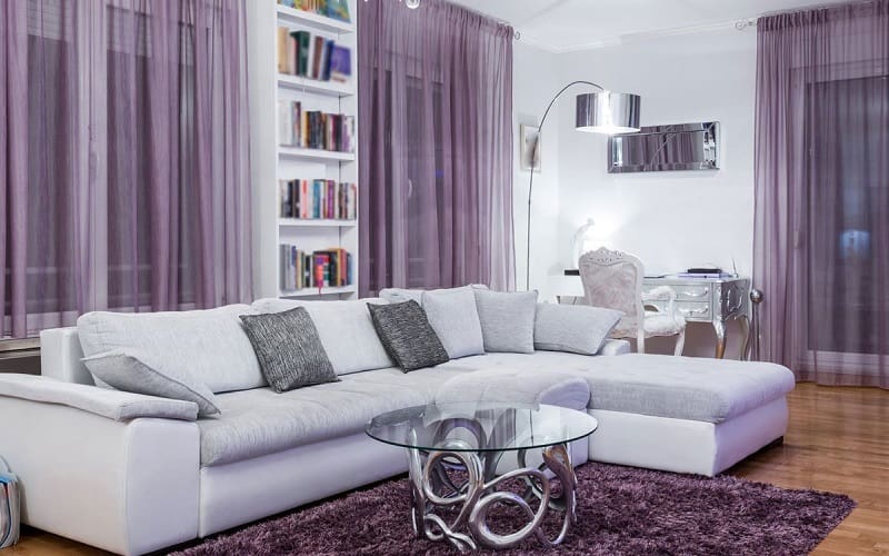 Lavender curtains on white walls inside living room with silver decoration details