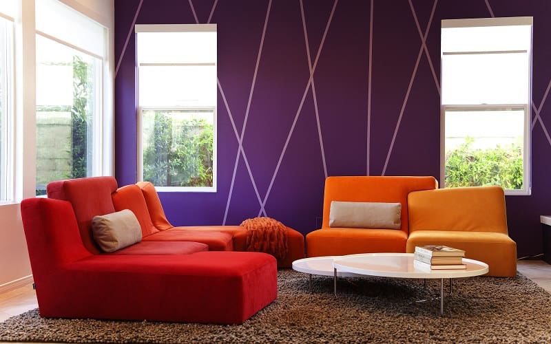 Sunset color combination with orange and red sofa and lavender wall