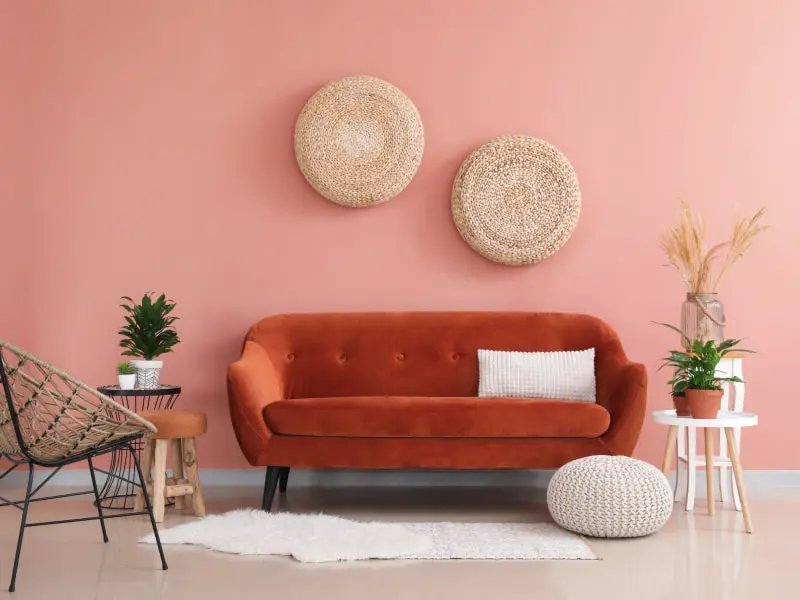 Living room with pink wall and dark orange sofa