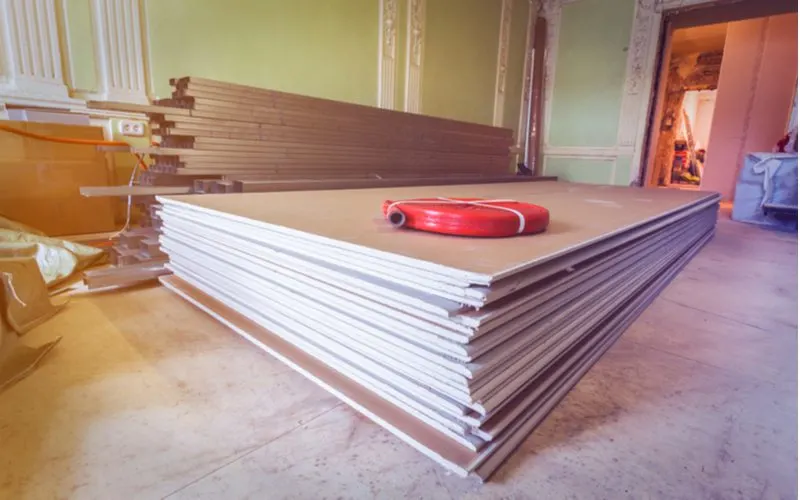 Various types of drywall lying on the ground in a home