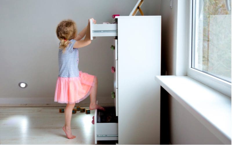 Young woman climbing on a dresser, leading parents to look for dresser alternatives