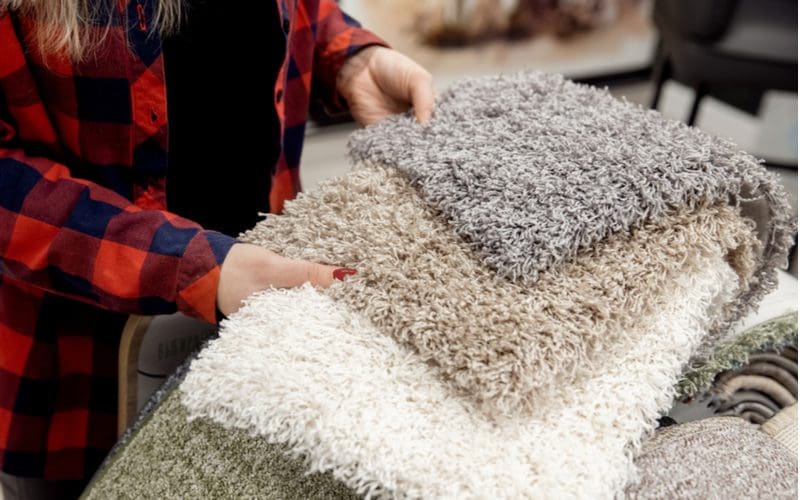 Woman rug shopping to answer what color rugs go with grey floors