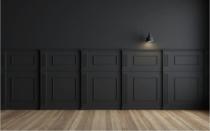 Black walls shown for a piece on what color paint goes with wood paneling