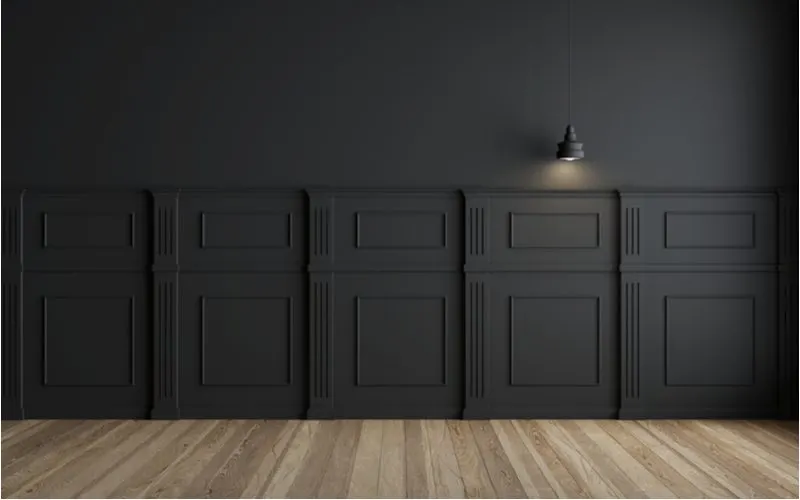 Black walls shown for a piece on what color paint goes with wood paneling