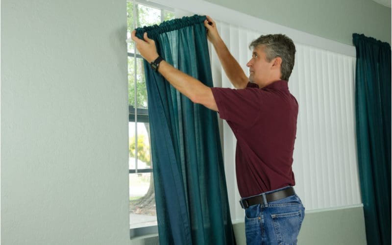 Guy hanging curtains with half-bar rods