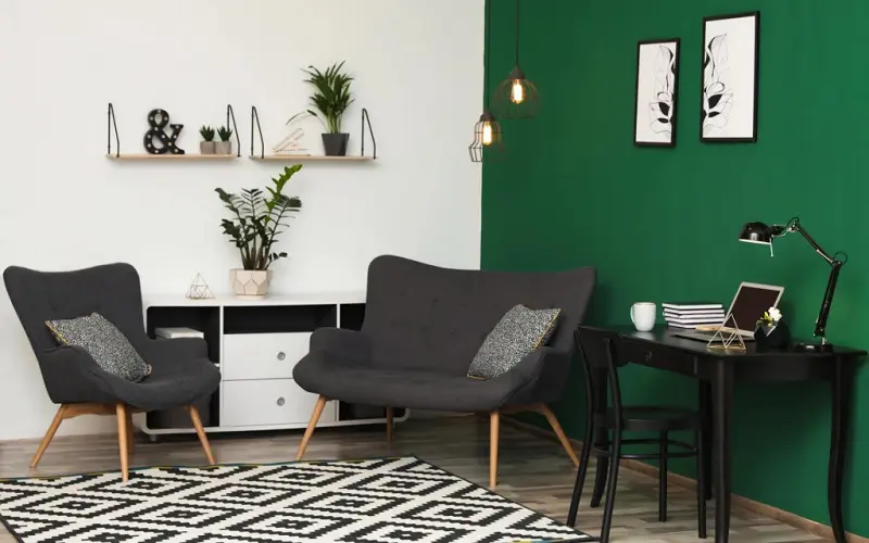 Living room corner with forrest green wall and charcoal gray chairs