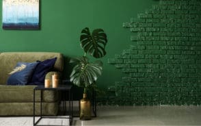 Room with green painted walls and plants and furniture for a piece titled What Colors Go With Forest Green