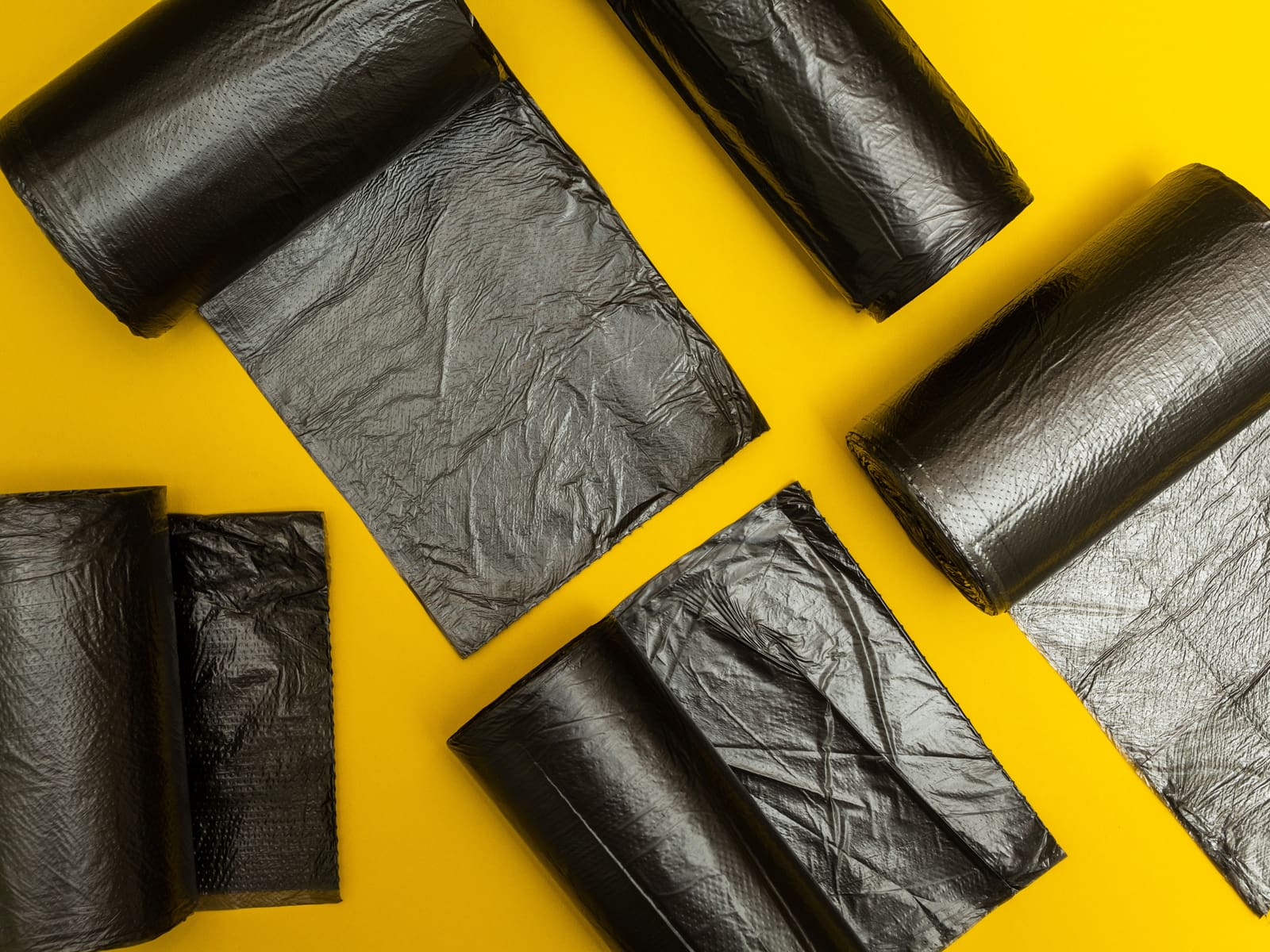 Black garbage bags in a layflat image on an orange background for a piece on trash can sizes