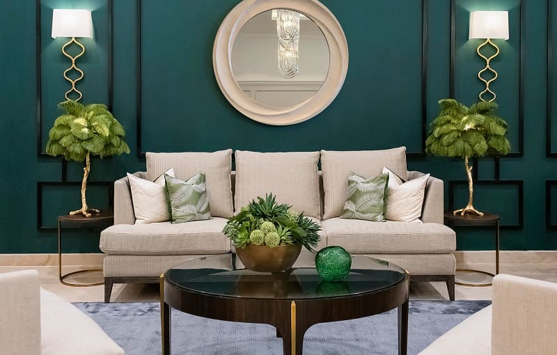 Beige furniture inside living room with dark green walls